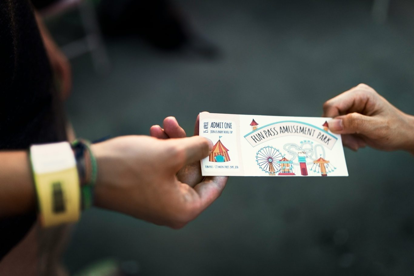 Zwei Hände übergeben eine bunte, dargestellte Eintrittskarte mit Illustrationen. Zwei Hände übergeben eine bunte, dargestellte Eintrittskarte mit Illustrationen.