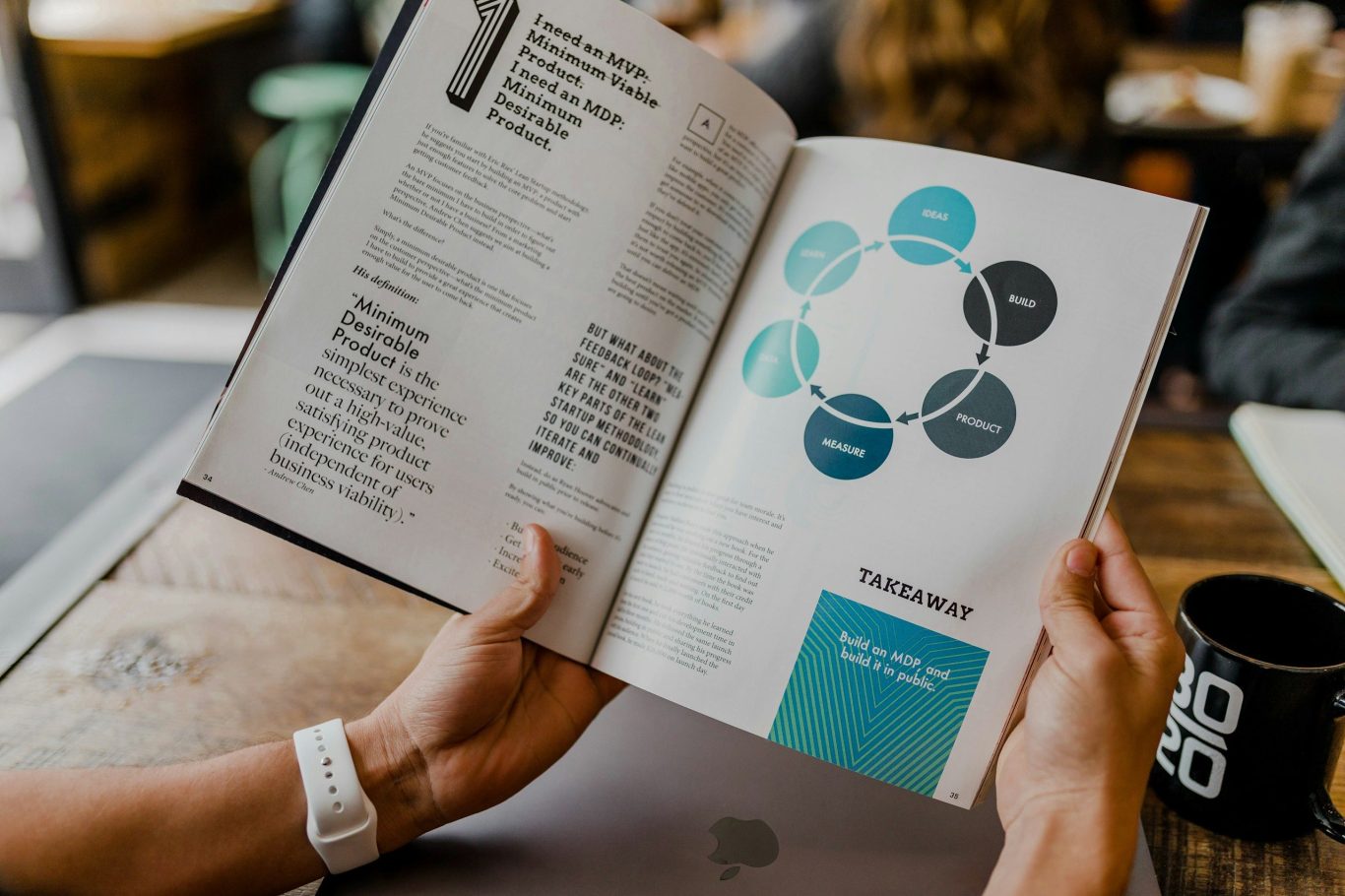 Hände halten ein aufgeschlagenes Buch mit Diagramm und Text auf einer Holzoberfläche. Hände halten ein aufgeschlagenes Buch mit Diagramm und Text auf einer Holzoberfläche.