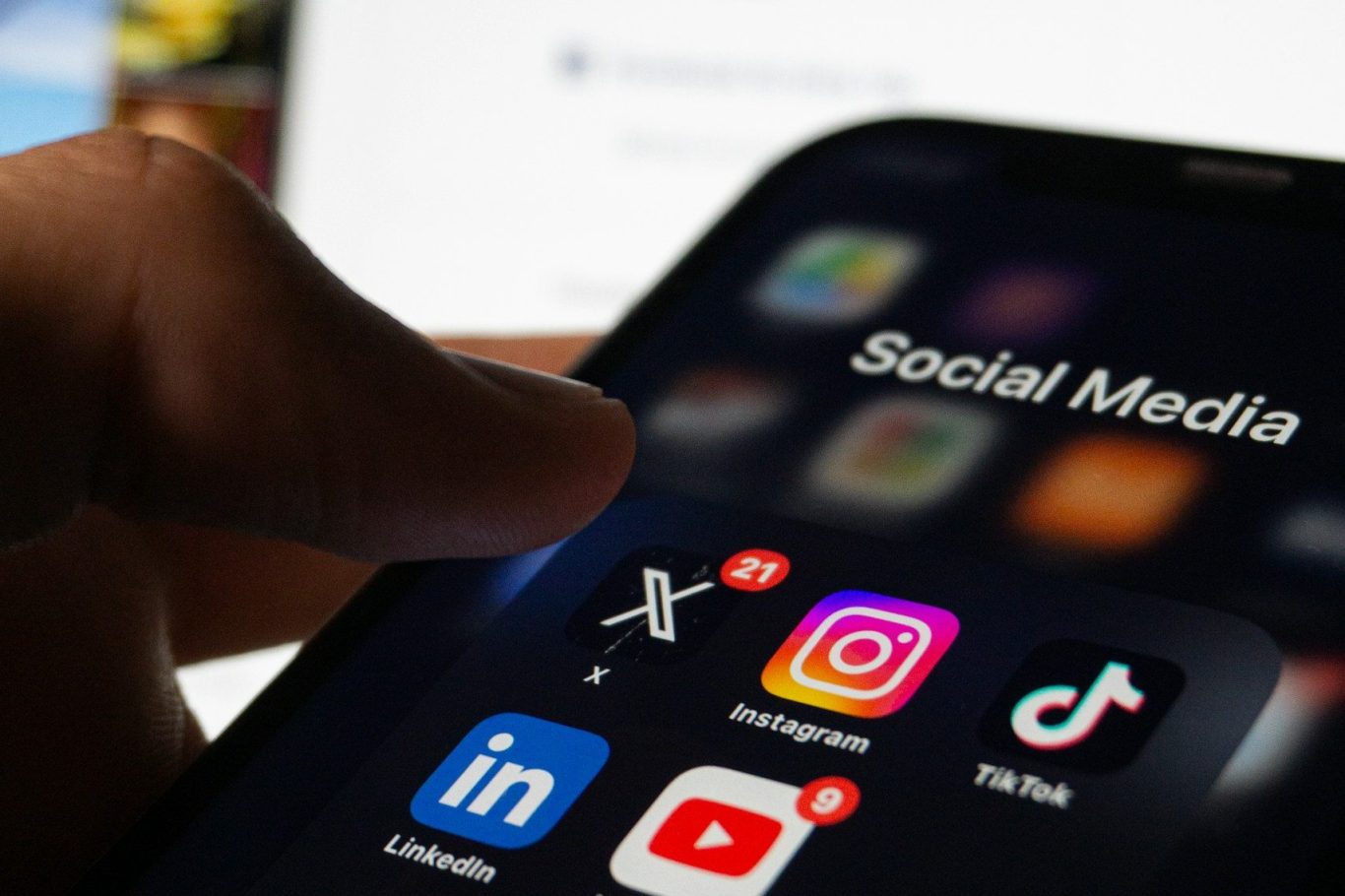 Smartphone mit sozialen Medien-Apps und einem Finger, der auf das X-Symbol zeigt. Smartphone mit sozialen Medien-Apps und einem Finger, der auf das X-Symbol zeigt.