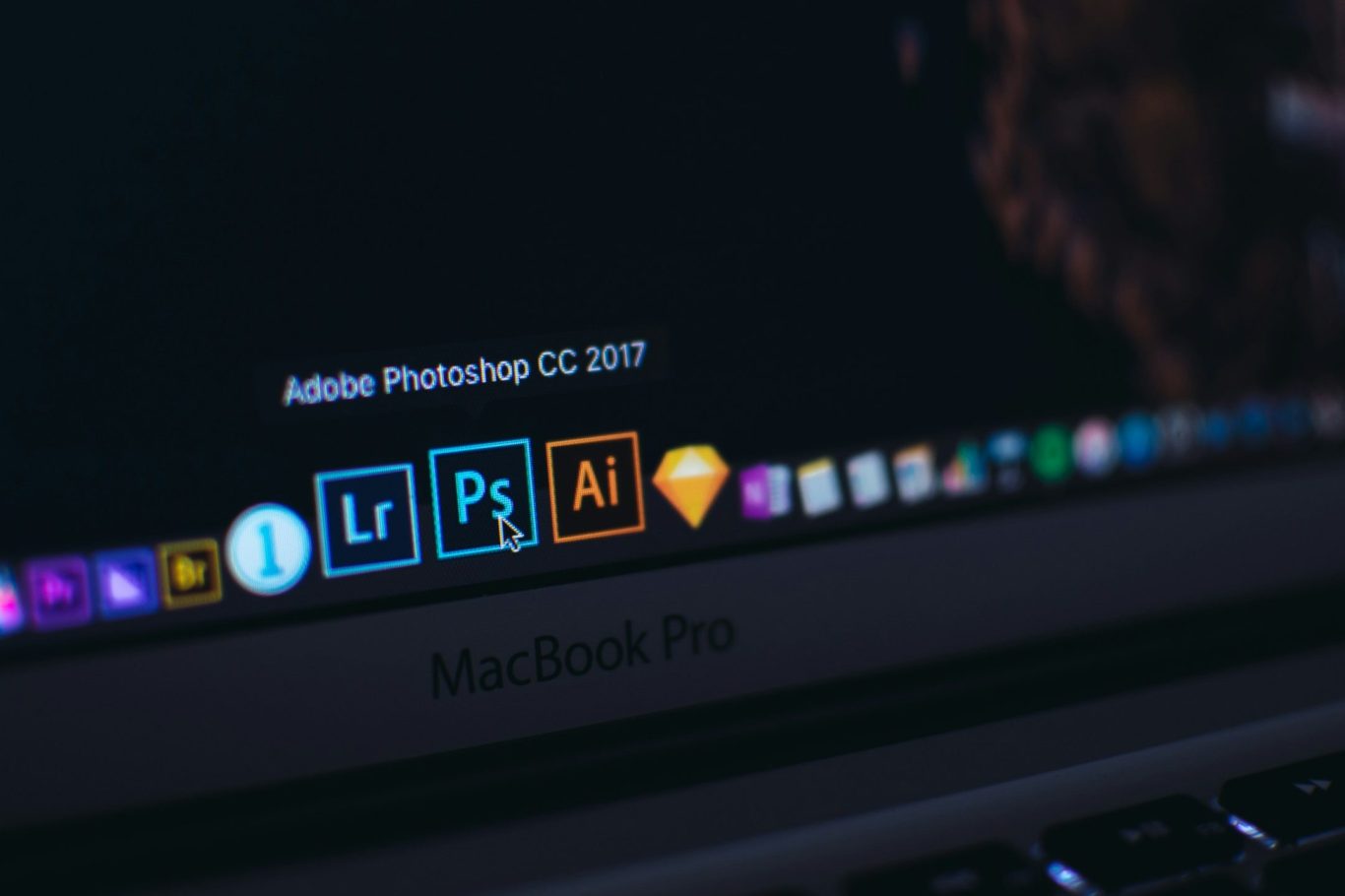 Logo von Adobe-Programmen Lightroom, Photoshop, Illustrator und Sketch auf einem Laptop-Bildschirm. Logo von Adobe-Programmen Lightroom, Photoshop, Illustrator und Sketch auf einem Laptop-Bildschirm.
