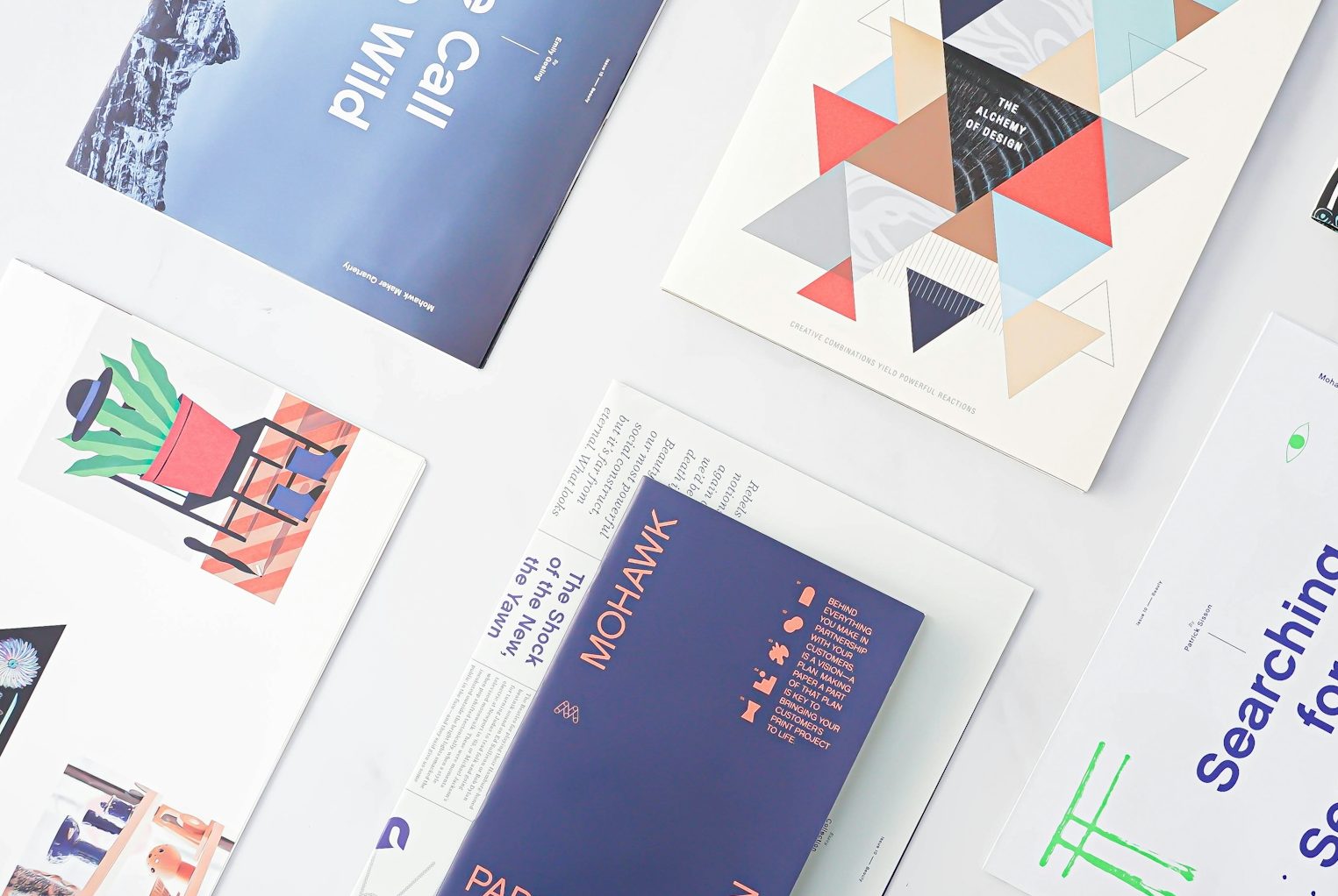 Eine Anordnung von verschiedenen Grafiken und Druckmaterialien auf einer Oberfläche.